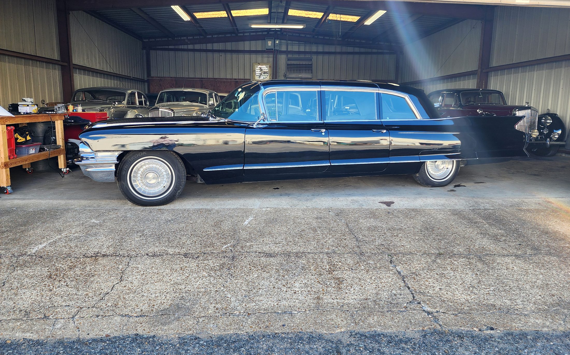 Waylon Jennings' black Cadillac Fleetwood limousine in profile, parked in an open garage